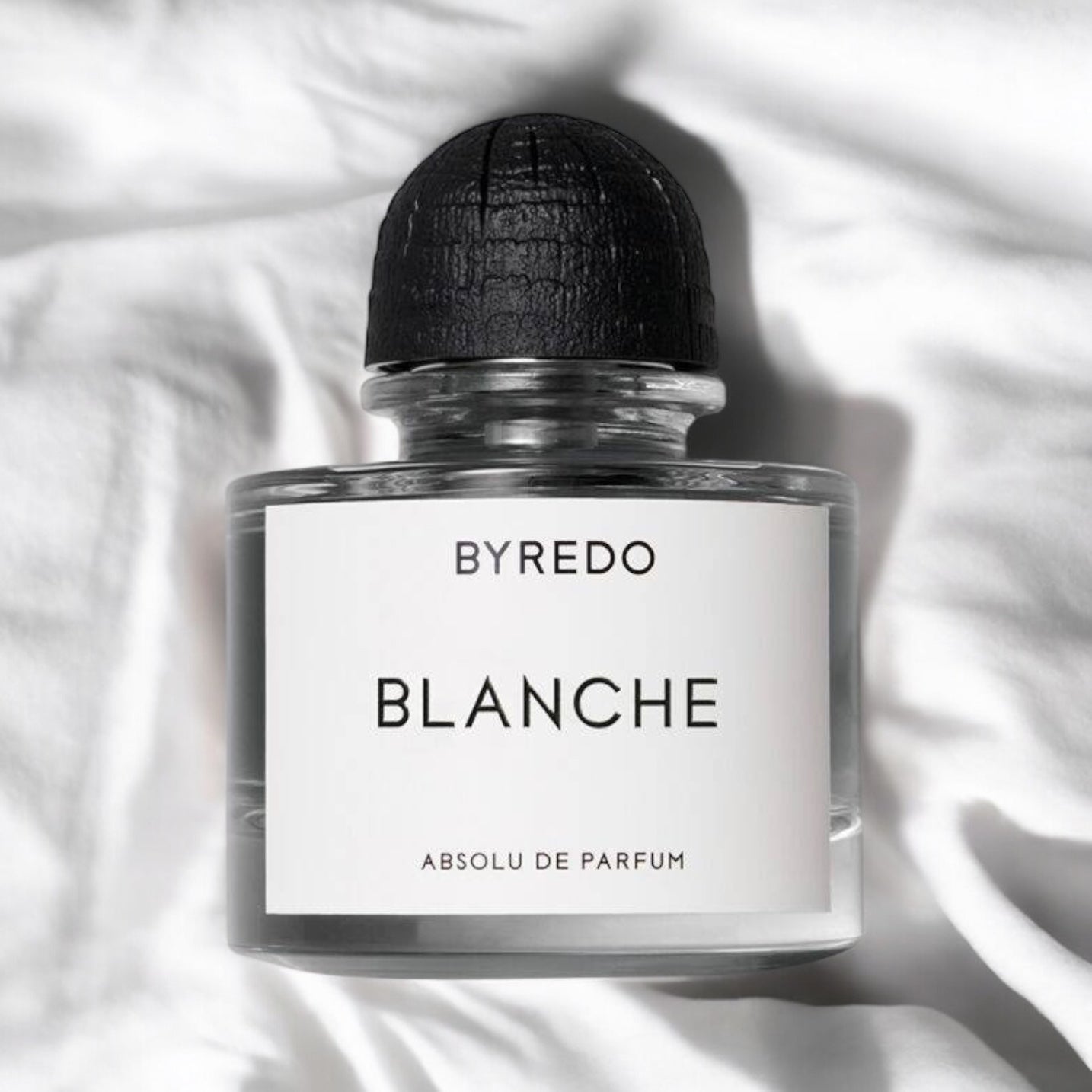 Close-up of a perfume sample of Blanche Absolu de Parfum, showcasing its airy yet musky floral notes with black pepper, jasmine, and warm amber woods.